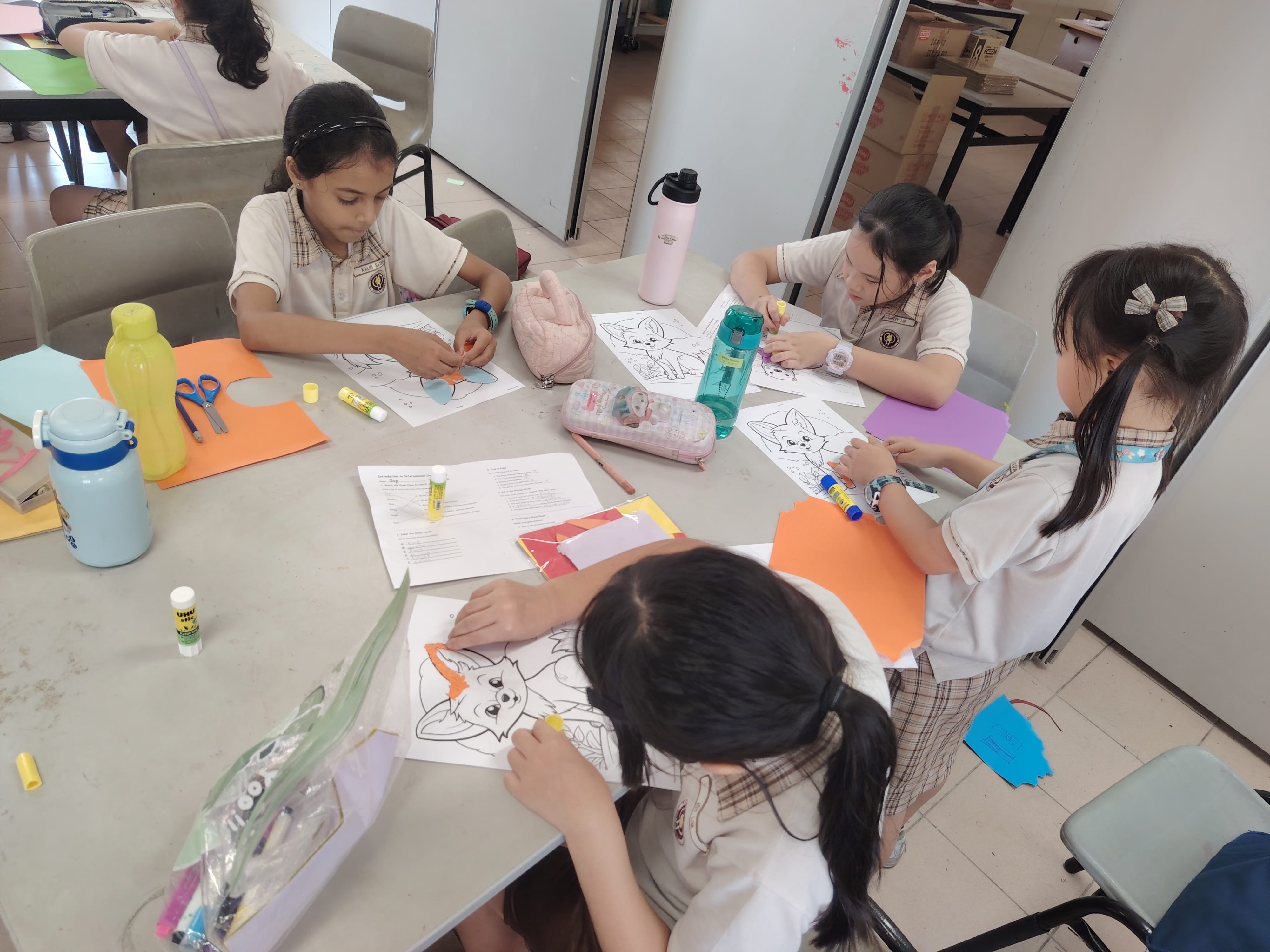 4 girls colouring a picture of a cat